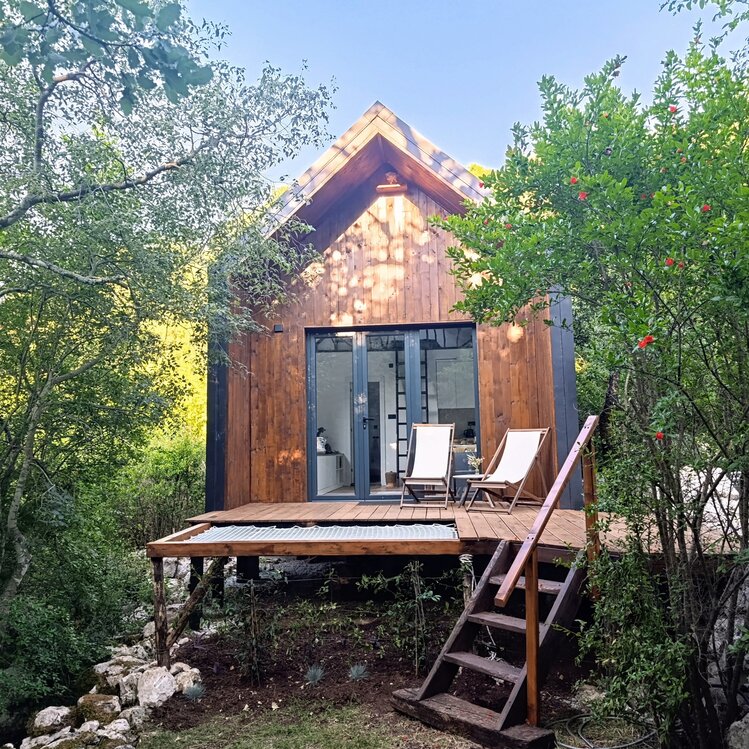 Luxurious eco cabin surrounded by mountains next to Lake Skadar with large window and lounge net to enjoy nature